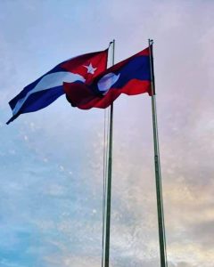 Flags of Laos and Cuba fly over That Luang Esplanade