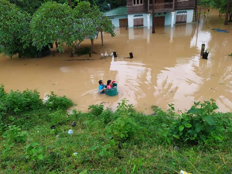 A man carries wife through floodwaters in basket