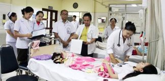 Doctors in Laos treating a patient with dengue fever.