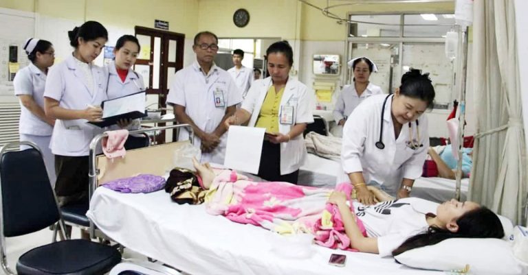 Doctors in Laos treating a patient with dengue fever.