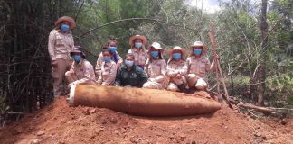 MAG UXO clearance team poses with a 2,000lb bomb uncovered in Khammouane province.