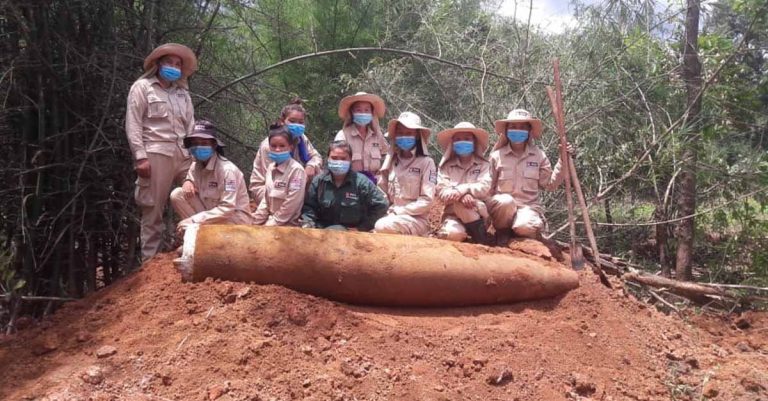 MAG UXO clearance team poses with a 2,000lb bomb uncovered in Khammouane province.