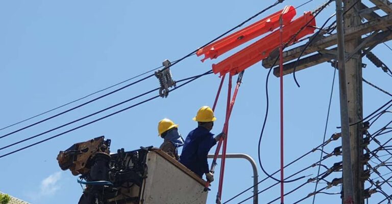 Electricite Du Laos workers repair an electricity line