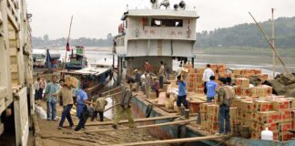 Cargo is offloaded from a boat in Houay Xai