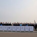 Donors, UN, and Lao government representatives pose with the COVAX vaccines.