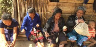 Four Khmu artisans demonstrate the stage of creating a Nature Bag from a plant stem while a young boy makes it a family affair.