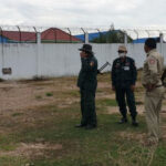 Police inspect the hole in the wall at Stung Treng Prison.