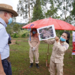 A Mines Advisory Group survey team member briefs Ambassador Haymond on a cluster sub-munition found in Latngon village, Xieng Khouang Province, in Laos.