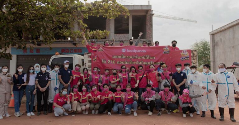 foodpanda employees and rescue personnel pose for a photograph after handing out happiness bags.