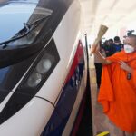 A monk sprinkles holy water on a train to ensure good luck and prosperity for the Laos-China Railway (Photo: CRI)