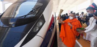 A monk sprinkles holy water on a train to ensure good luck and prosperity for the Laos-China Railway (Photo: CRI)