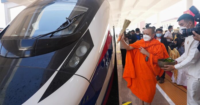 A monk sprinkles holy water on a train to ensure good luck and prosperity for the Laos-China Railway (Photo: CRI) A monk sprinkles holy water on a train to ensure good luck and prosperity for the Laos-China Railway (Photo: CRI)