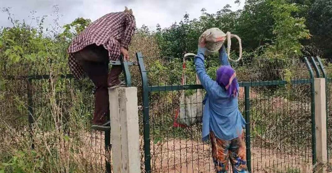 The locals try to climb Lao-China railway fence.