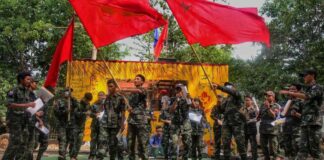 Members of the "Peacock Generation" activist troupe, some of whom are dressed as part of the "People's Defence Forces" (PDF), waving Yangon Student Union flags during a traditional "Thangyat" performance in Kayin state. (Photo: AFP)