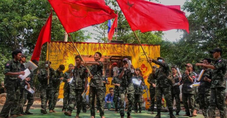 Members of the "Peacock Generation" activist troupe, some of whom are dressed as part of the "People's Defence Forces" (PDF), waving Yangon Student Union flags during a traditional "Thangyat" performance in Kayin state. (Photo: AFP)