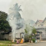 An elderly lady burns waste in Luang Prabang.