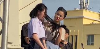 A teacher forcibly cuts a student's hair in Thailand.