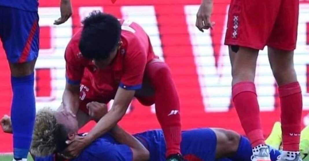 Lao player gives first aid to Cambodian at SEA Games