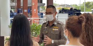 Thai immigration official speaks with Lao citizens entering Thailand