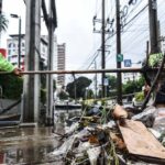 Cleaning crew scoop garbage from drains in Bangkok.