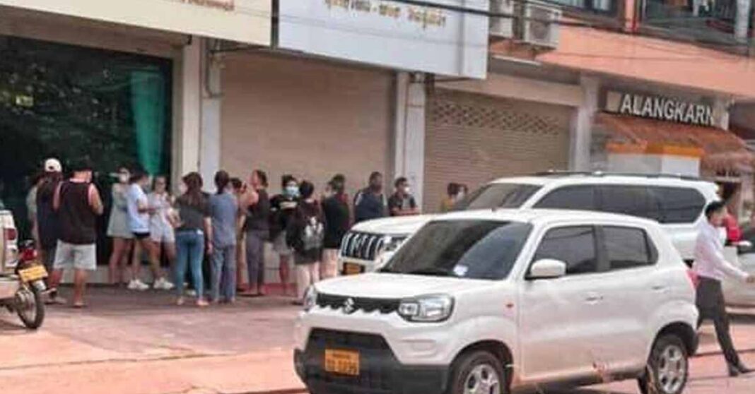 Victims gather outside the jewelry store owned by Phonethip Xaypanya