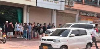 Victims gather outside the jewelry store owned by Phonethip Xaypanya