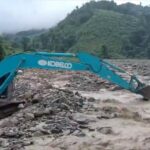 An excavator desperately tries to clear a path along a major road hit by a landslide in Kasi District, Vientiane Province.