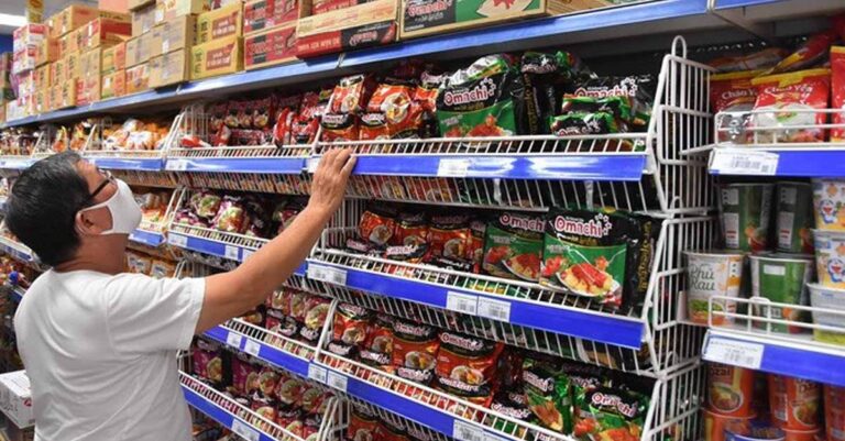 Customer browses instant noodles at a Vietnamese supermarket