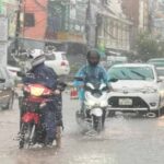 Motorists in Vientiane commuting through rains this morning.