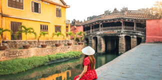 A woman sitting next to Thu Bồn river in Hoi An, Vietnam