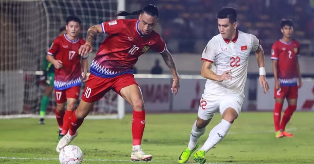 Billy Ketkeophomphone defends against Vietnamese rivals at the AFF Mitsubishi Electric Cup Group B football match in Vientiane