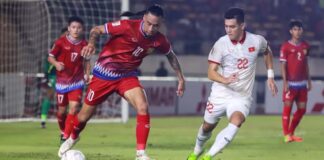 Billy Ketkeophomphone defends against Vietnamese rivals at the AFF Mitsubishi Electric Cup Group B football match in Vientiane