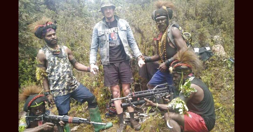 In this undated photo released by West Papua Liberation Army, the armed wing of the Free Papua Movement, Papuan separatist rebels pose for a photo with a man they said is New Zealander pilot Phillip Mark Mehrtens who they took hostage last week, at an undisclosed location in Papua province, Indonesia. Mehrtens, a pilot for Indonesian aviation company Susi Air, was abducted by the independence fighters who stormed his single-engine plane shortly after it landed on a small runway in Paro in remote Nduga district. (West Papua Liberation Army via AP)