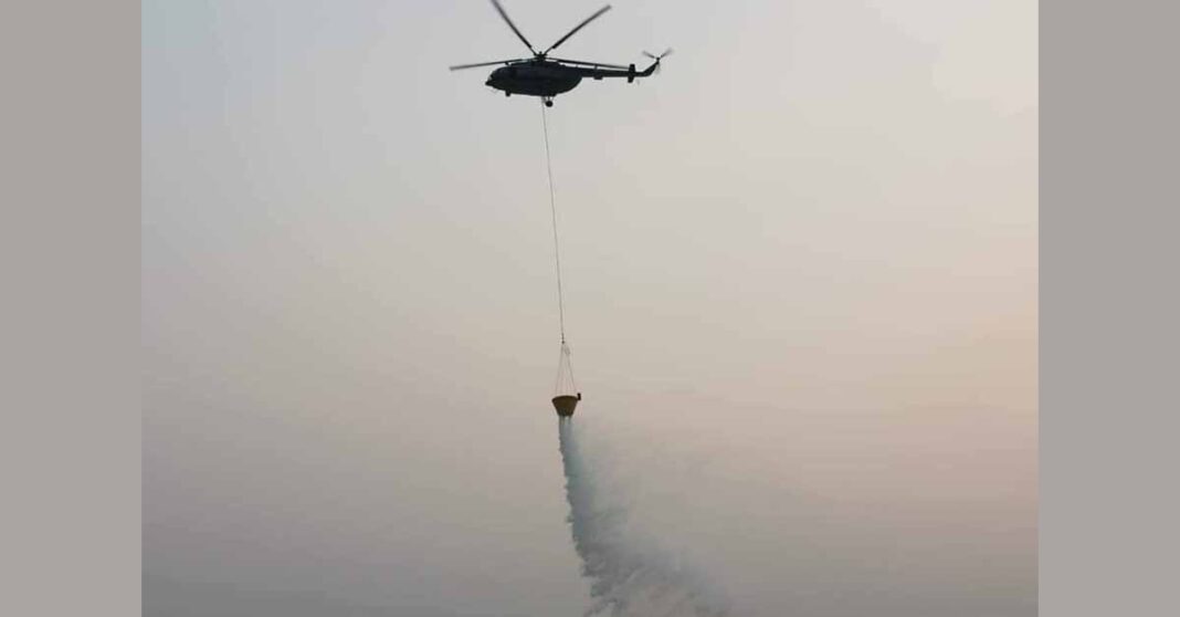 A Lao military helicopter attempts to fight a forest fire in Vientiane's Sangthong Province.