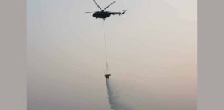 A Lao military helicopter attempts to fight a forest fire in Vientiane's Sangthong Province.