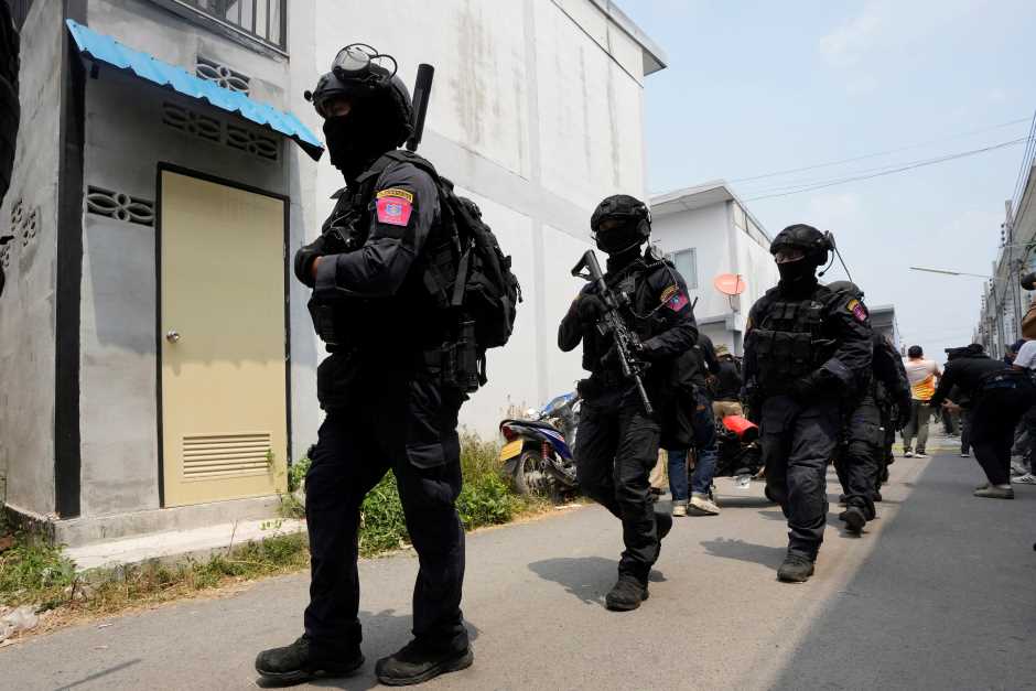 A group of armed commando police leave from the home of a senior police officer in Bangkok, Thailand, Wednesday, March 15, 2023. Thai police have arrested a fellow officer who fired multiple gunshots from his home in Bangkok which forced an over 24 hours-long standoff after his colleagues tried to take him to be treated for mental illness. (AP Photo/Sakchai Lalit)