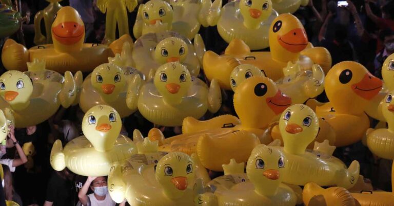 Inflatable yellow ducks, which have become good-humored symbols of resistance during anti-government rallies, are lifted over a crowd of protesters in Bangkok, Thailand, Nov. 27, 2020. (AP Photo/Sakchai Lalit, File)