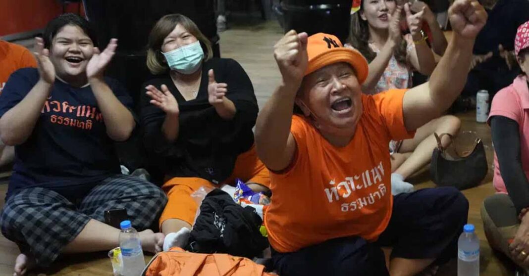 Supporters of Move Forward party cheer as they watch the counting of votes on television at Move Forward Party headquarters in Bangkok, Thailand