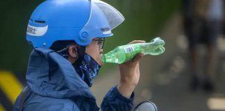 A delivery driver takes a drink as he waits at a traffic light on an unseasonably hot day in Beijing, Saturday, June 24, 2023. Authorities continued a rare red alert for high temperatures in parts of China's capital on Saturday, the highest level of warning, as highs were once again expected to climb to around 40 degrees Celsius (104 degrees Farenheit). (AP Photo/Mark Schiefelbein)