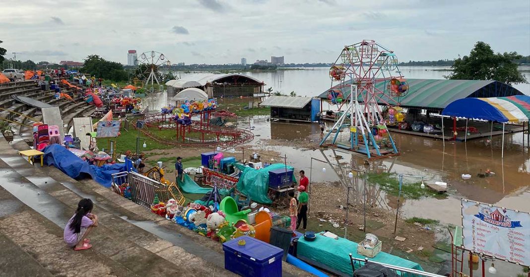 Vendors rush to relocate their belongings as floodwaters suddenly inundate the area along the Mekong River in Vientiane Capital.