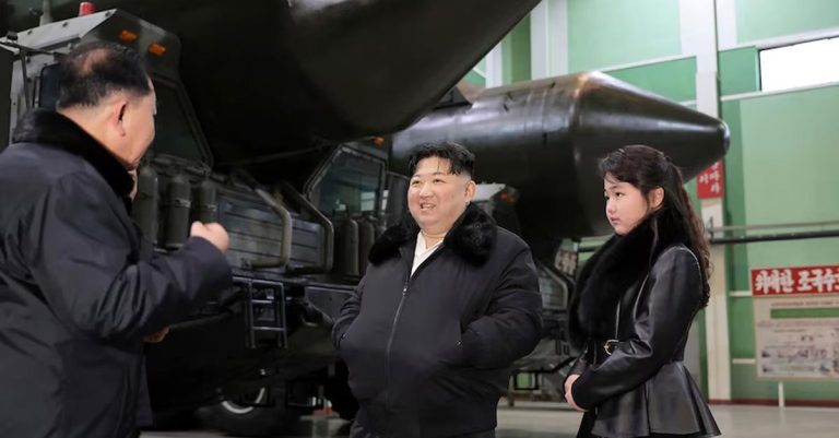 North Korean leader Kim Jong Un, centre, with his daughter were visiting a factory producing transport erector launches prior to the artillery shelling.(AP: Korean Central News Agency/Korea News Service )