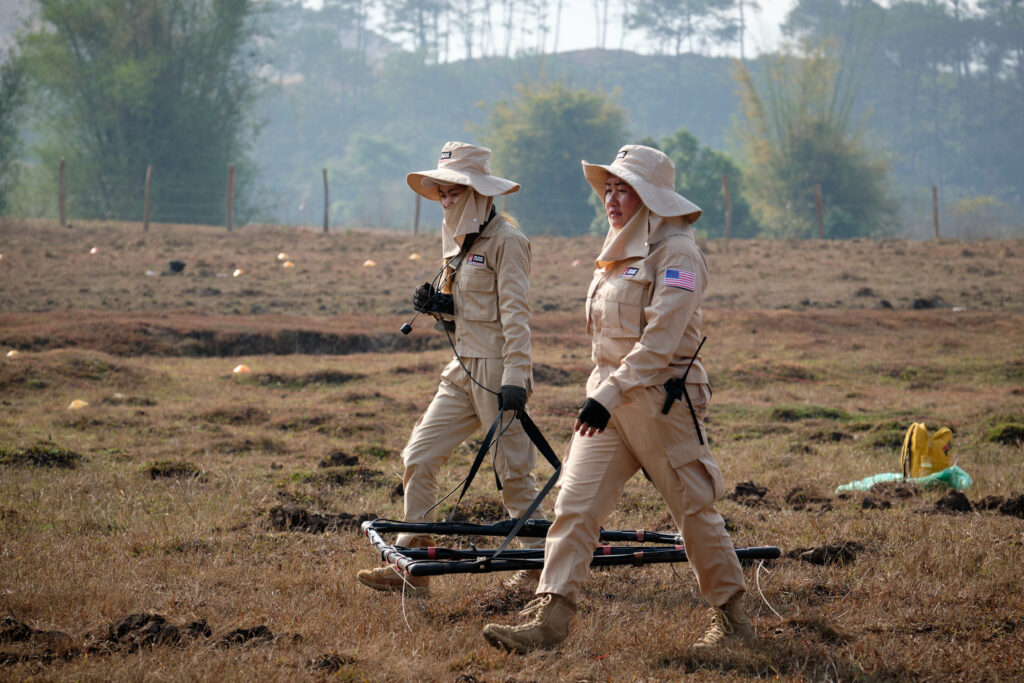 MAG clearance team members use a large-loop detector to search for unexploded bombs on farmland in Xieng Khouang province. ©MAG/Bart Verweij