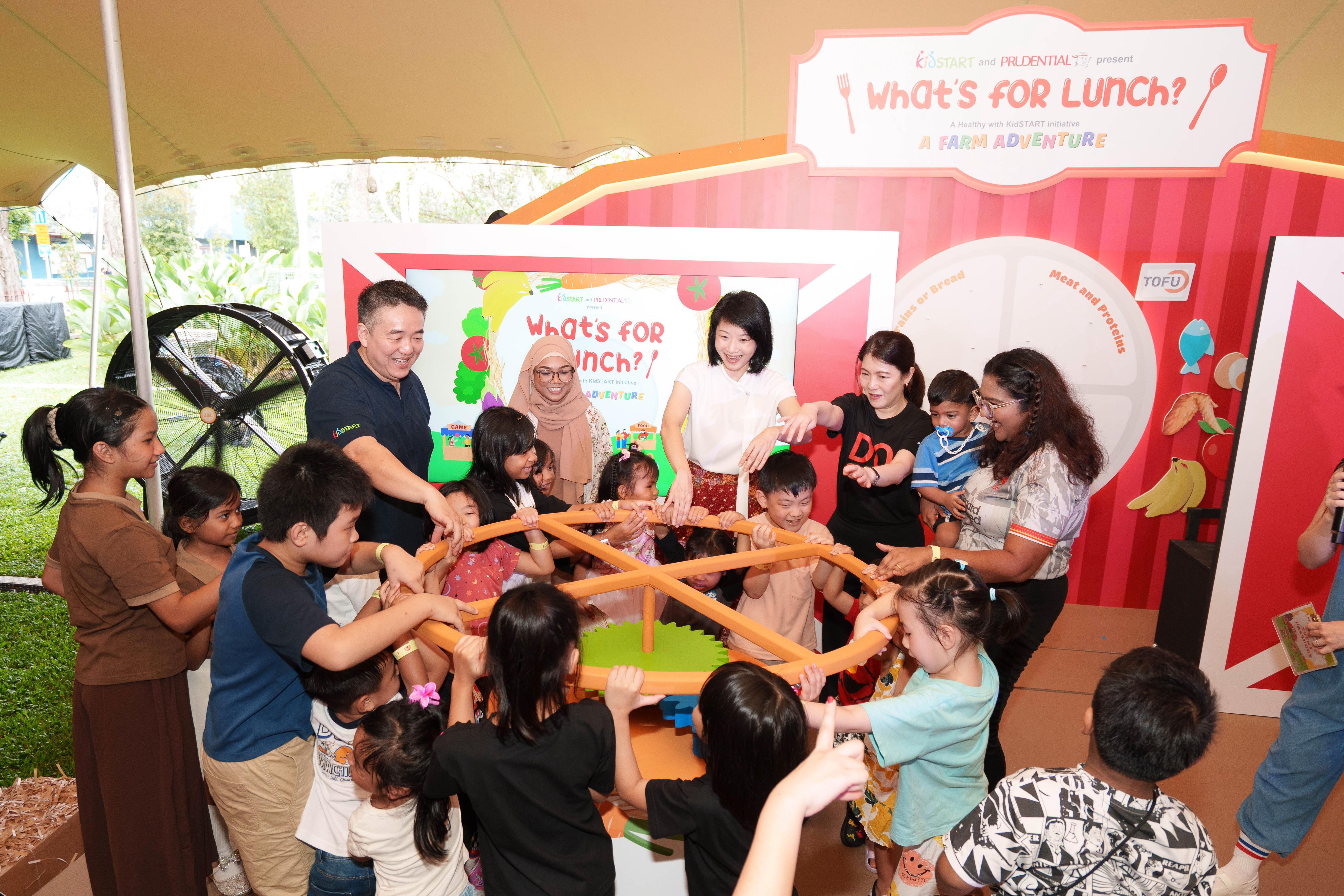 (From left) Mr Joel Tan, Chief Executive Officer of KidSTART Singapore, KidSTART mother Ms Nur Farah, Ms Sun Xueling, Minister of State for Social and Family Development, Ms Chan San San, Chief Executive Officer of Prudential Singapore, and KidSTART mother Ms Sangeetha D/O Jagathisa, join more than 600 parents and children at the What’s for Lunch? A Farm Adventure food expo, at The Lawn @ The Foothills, Fort Canning Park.