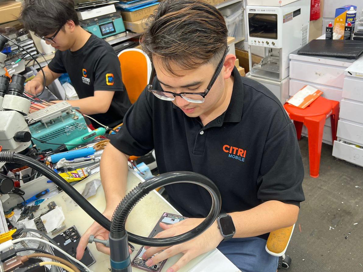 A Citri Mobile technician performing internal diagnostics at a fully equipped repair station in Singapore.