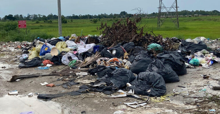 Trash Piles Up on New Vientiane Road Despite Heavy Fines, Warning Sign