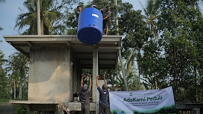 Workers install a large blue water tank on a structure as part of the AdaKami Peduli initiative to provide clean water access in Dusun Banjarsari, South Lampung Workers install a large blue water tank on a structure as part of the AdaKami Peduli initiative to provide clean water access in Dusun Banjarsari, South Lampung