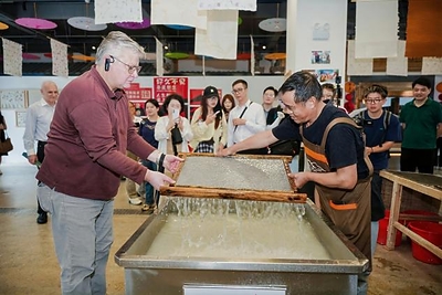 H.E. Mr. Karlis Eihenbaums,ambassador of Latvia to China, tries his hand at the traditional craft of Xuan papermaking. H.E. Mr. Karlis Eihenbaums,ambassador of Latvia to China, tries his hand at the traditional craft of Xuan papermaking.